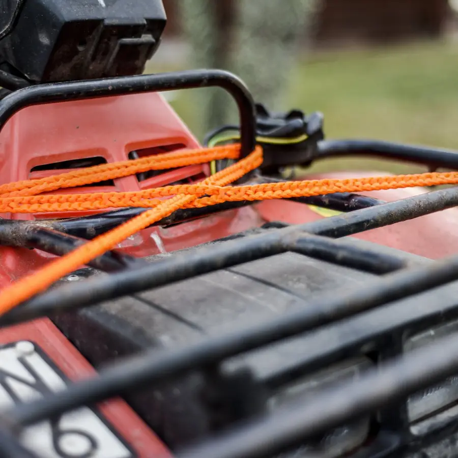 Cargo strapped to a quad bike rack with orange RunLock